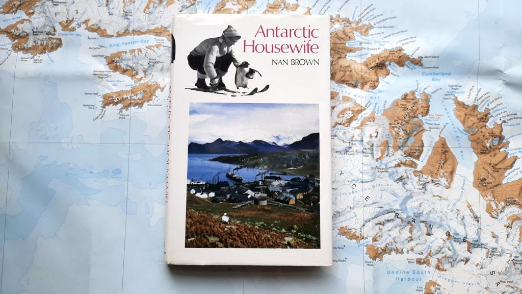 A copy of 'Antarctic Housewife' by Nan Brown. The book sits on a background of the map of South Georgia