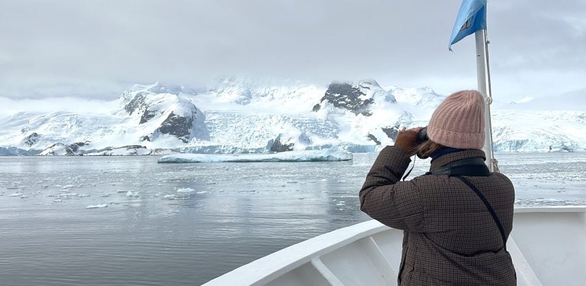 Tourist on a cruise ship looking out over the Antarctic Peninsula